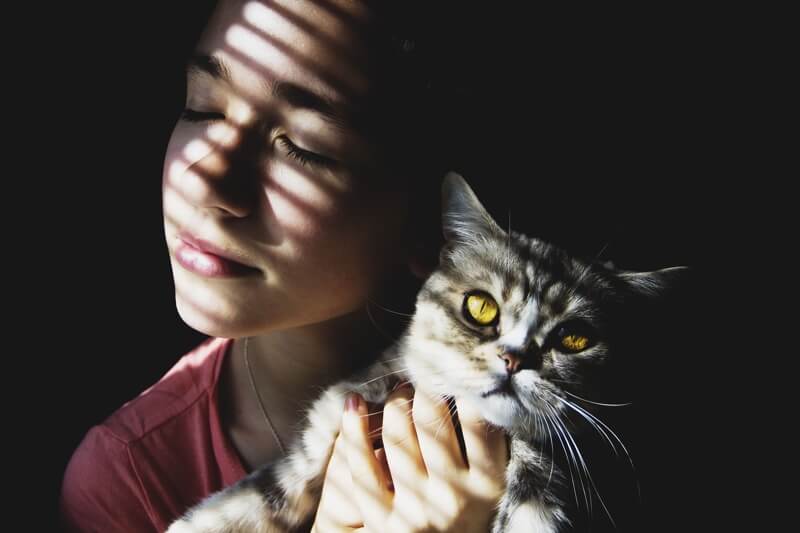 how much does preventive care coverage cost _ woman holding a cat with yellow eyes