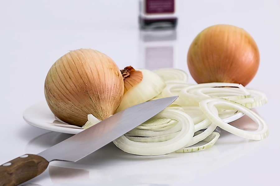 sliced yellow onions and a knife with a wooden handle