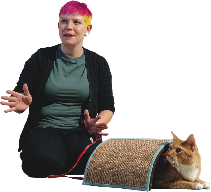 Tabitha Kucera kneeling next to an orange cat