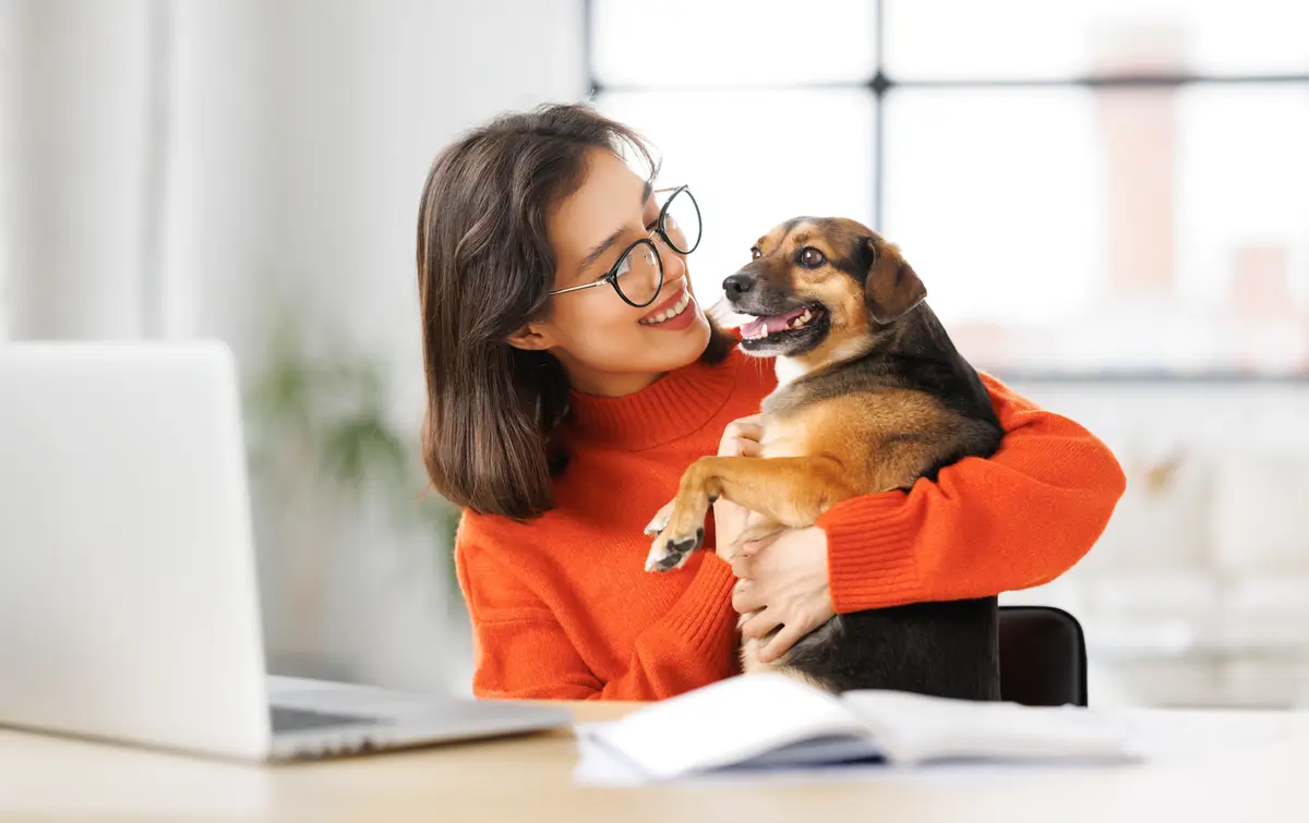 Woman smiling and holding dog